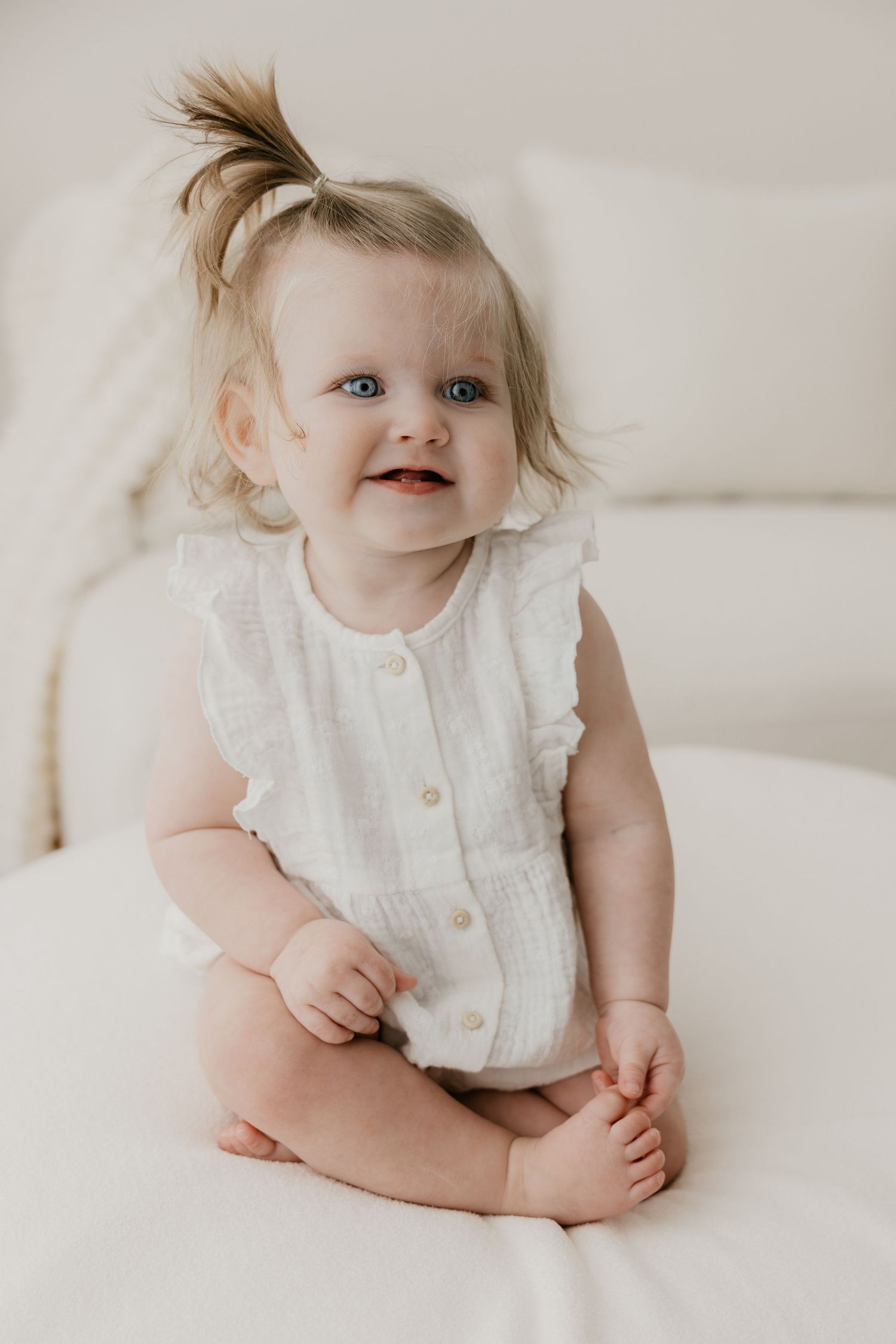 Sitter baby tijdens milestone fotoshoot voor eerste verjaardag, genietend van cakesmash