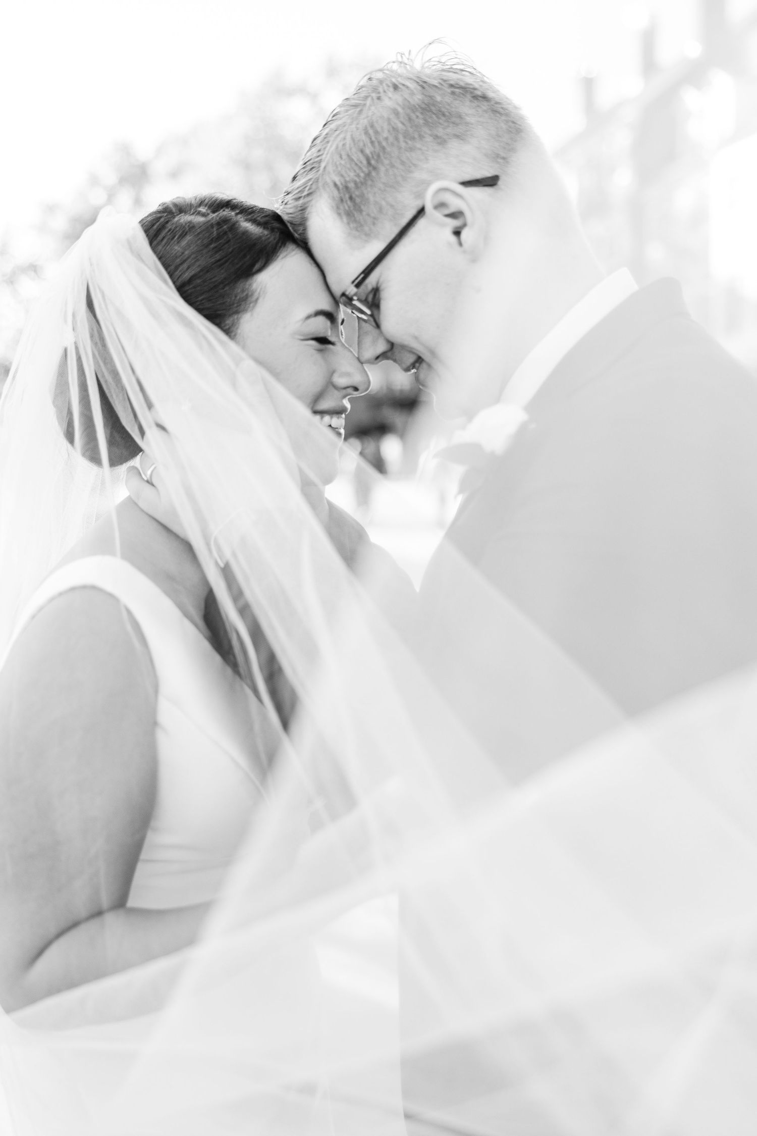 A series of black and white romantic wedding photos showing tender moments between a bride and groom.
