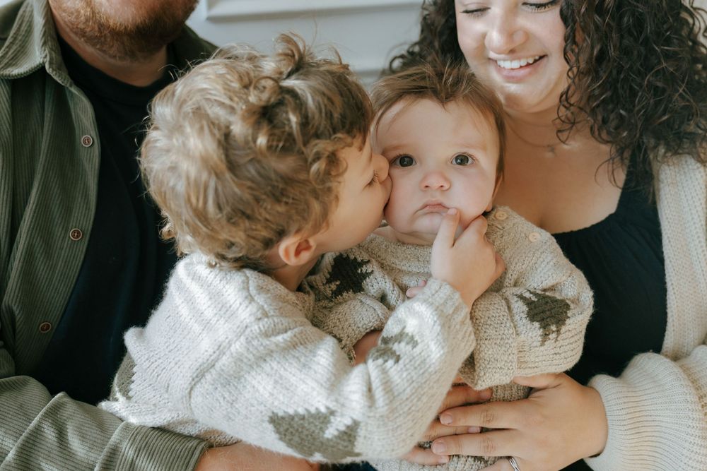 A series of candid family photos showing tender moments of embraces and kisses between loved ones.