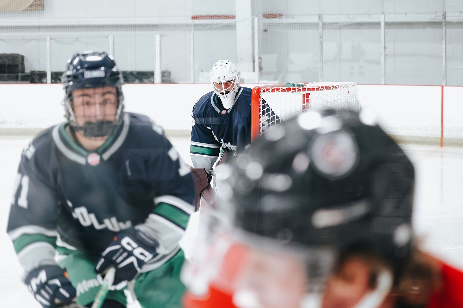 Hockey players in dark jerseys compete during an intense ice hockey match.
