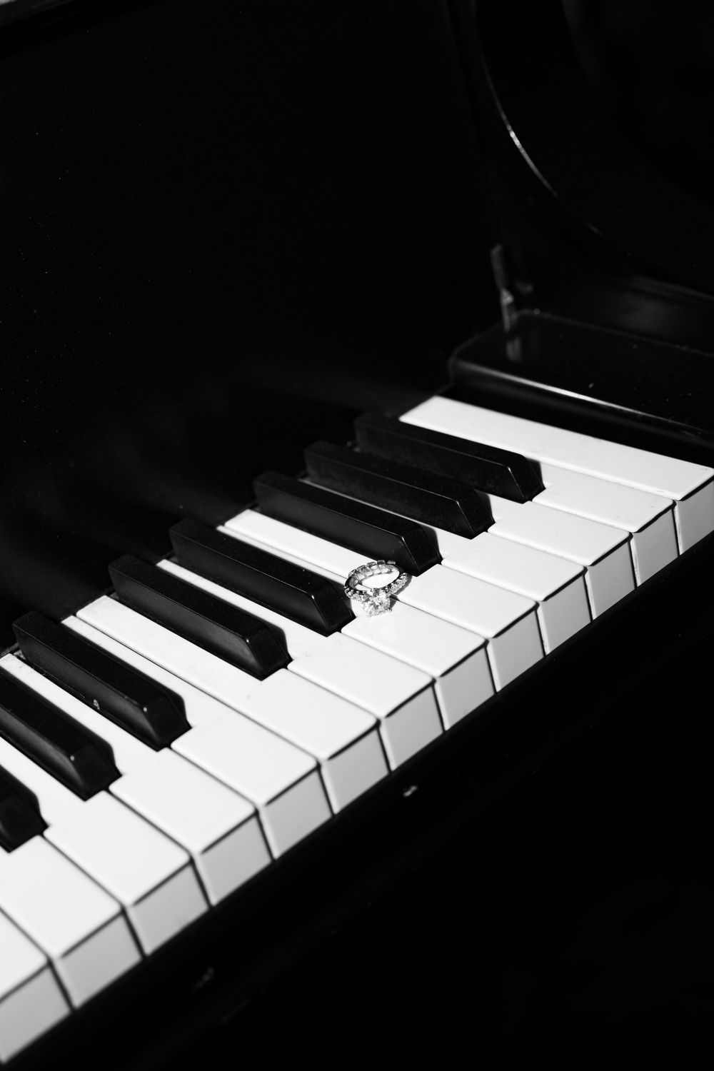 Black and white piano keys create a dramatic diagonal composition with strong contrast and shadows.