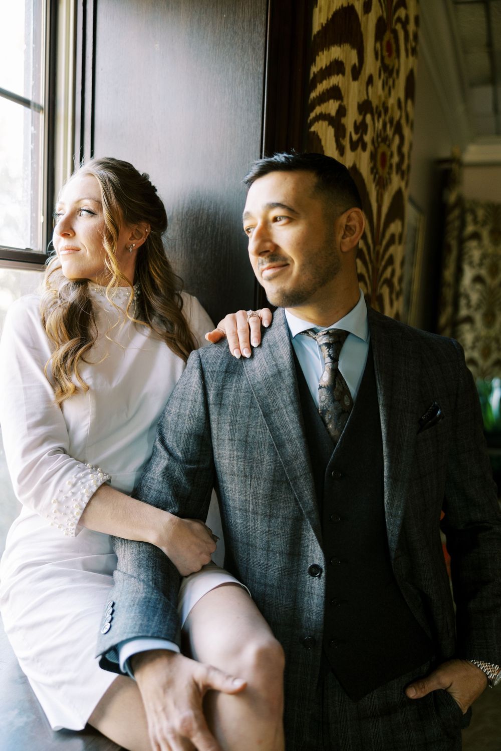 Romantic couple in elegant attire share intimate moments in a series of stylish indoor portraits.