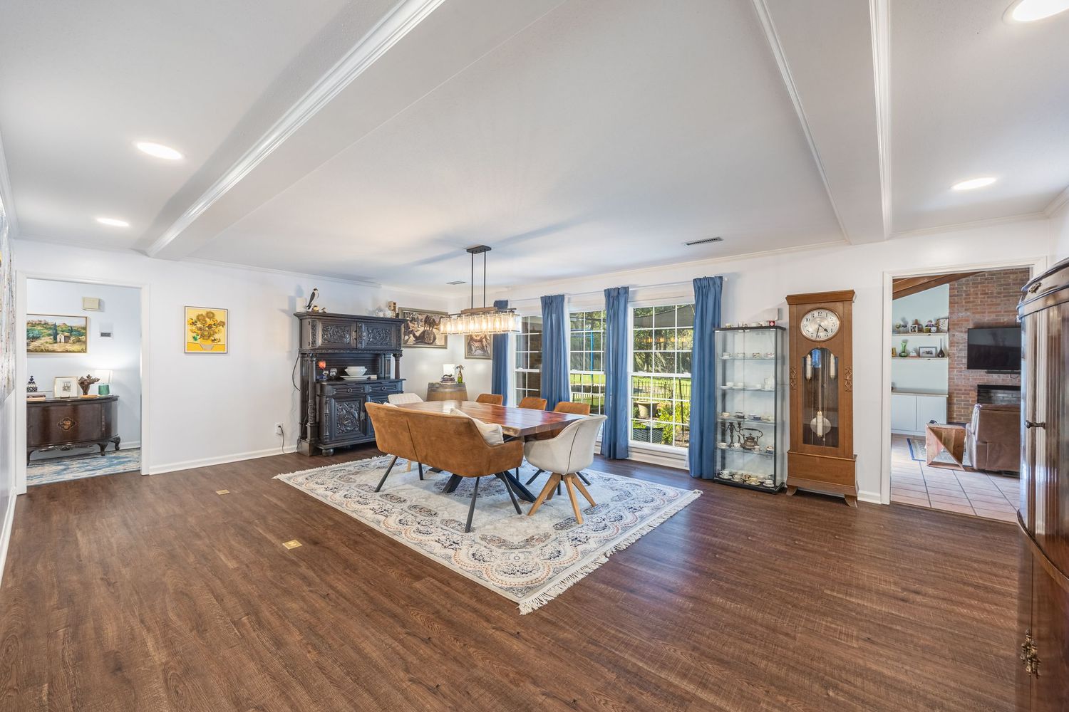 Large covered patio with wood ceiling and ceiling fan offers panoramic views of a lake through floor-to-ceiling windows in Enterprise, AL.