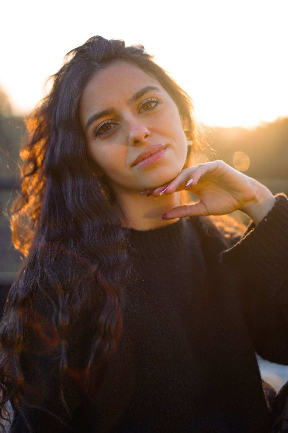 Sunset portrait with warm golden lighting and long dark hair.