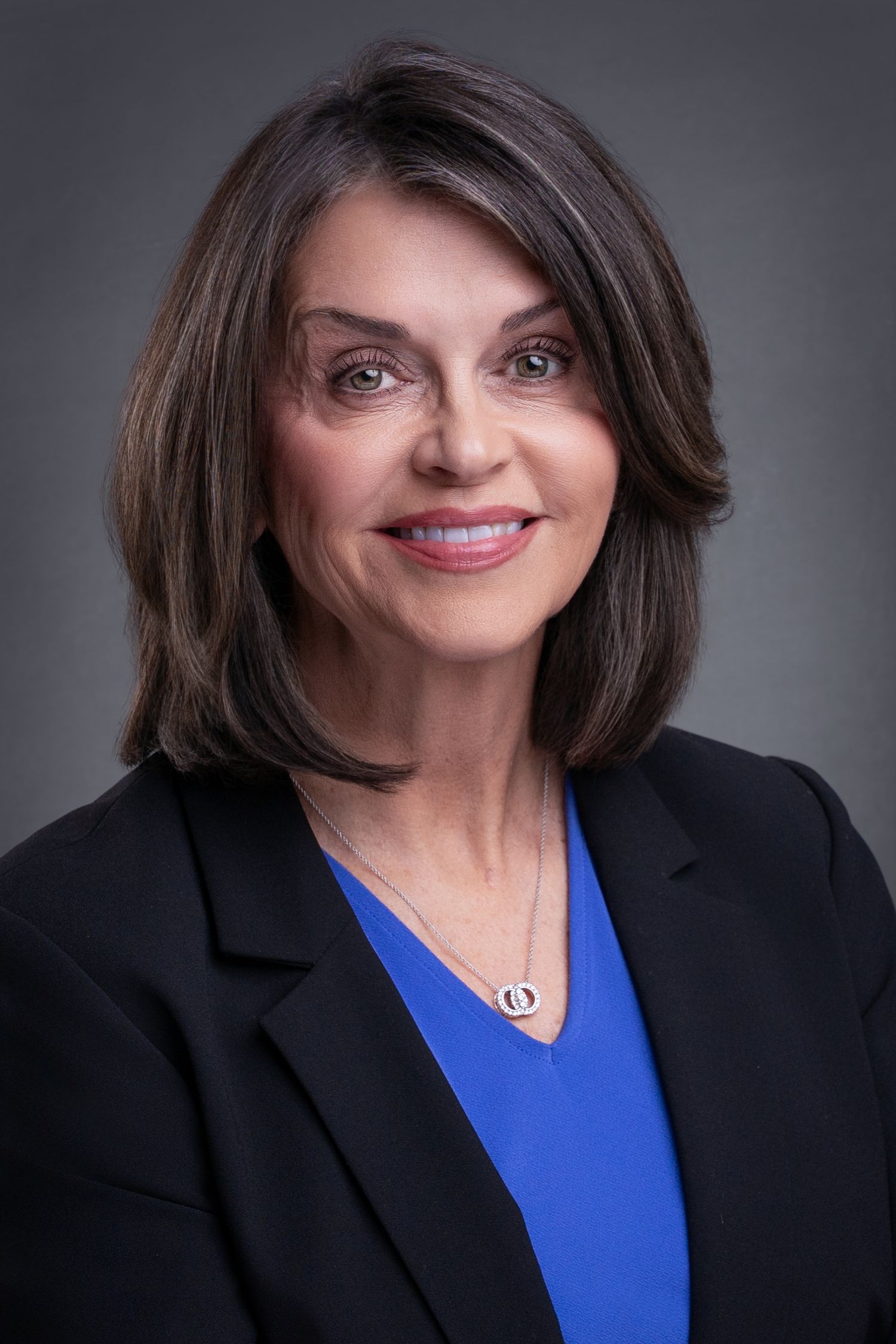 Studio headshot of an East Tennessee realtor wearing a blazer and blue blouse taken by headshot and personal branding photographer