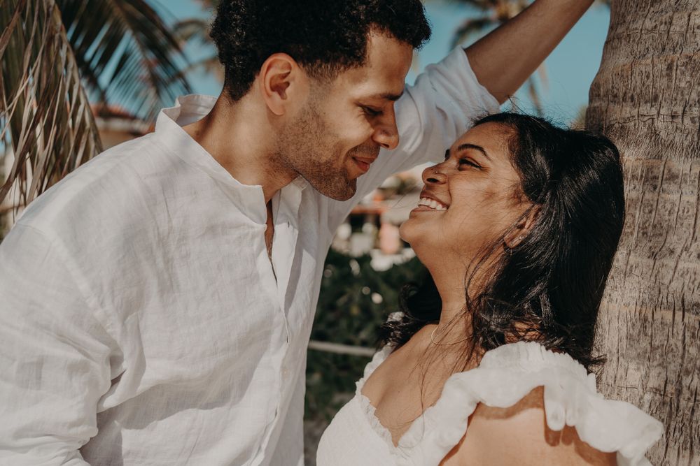 Intimate close-up of couple among palm trees during a beach photoshoot photoshoot in Puerto Morelos.