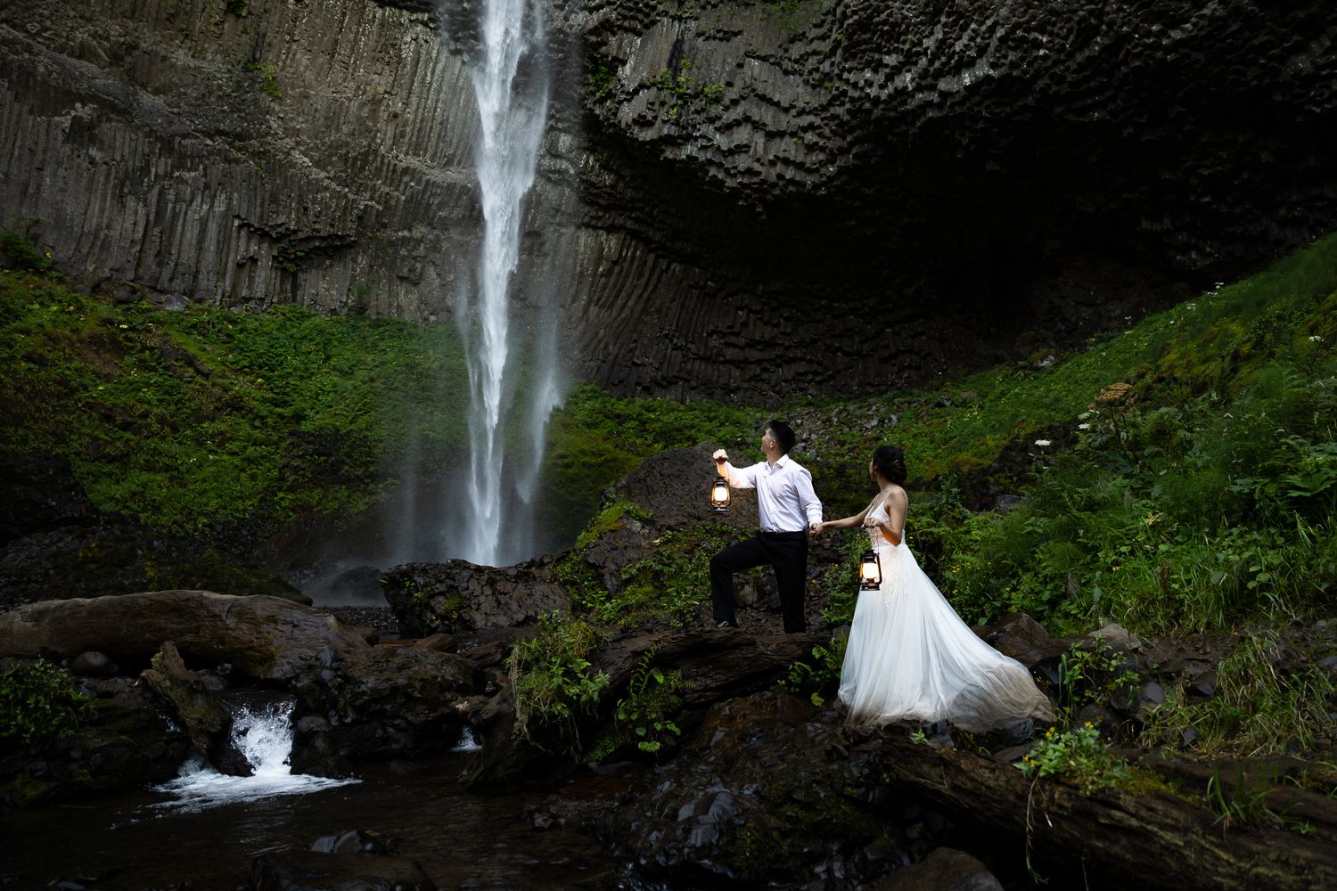 Bride and groom celebrate at Latourell Falls with vintage lanterns in Oregon.
