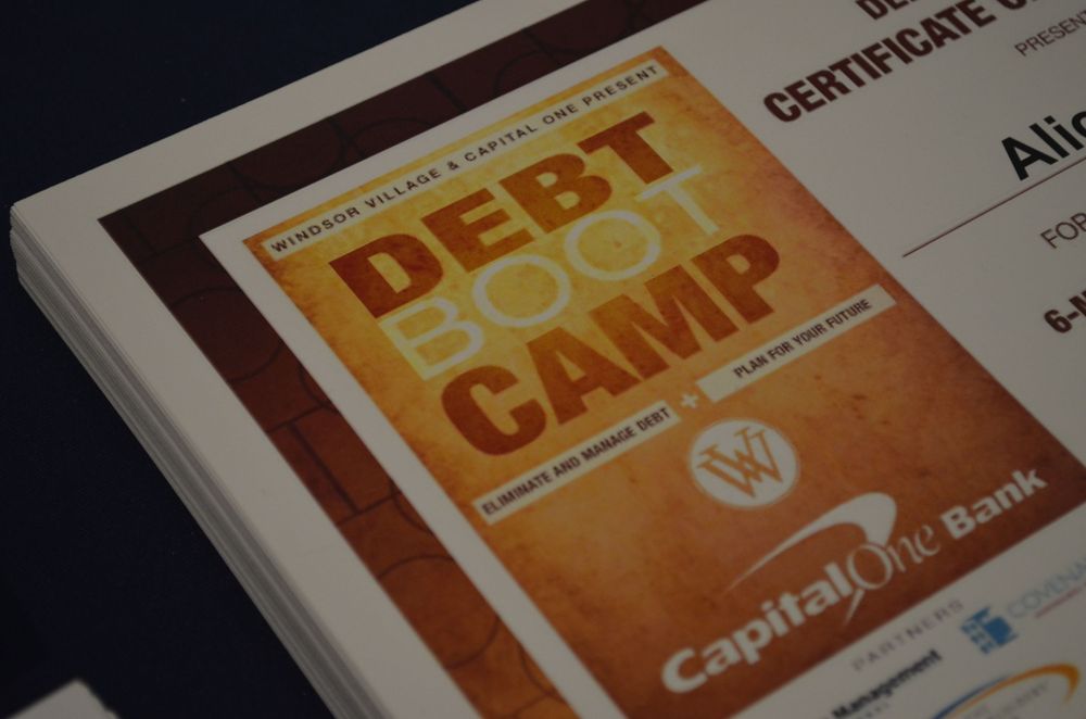 Capital One Bank Debt Boot Camp financial literacy program booklet on a table at an educational seminar event.