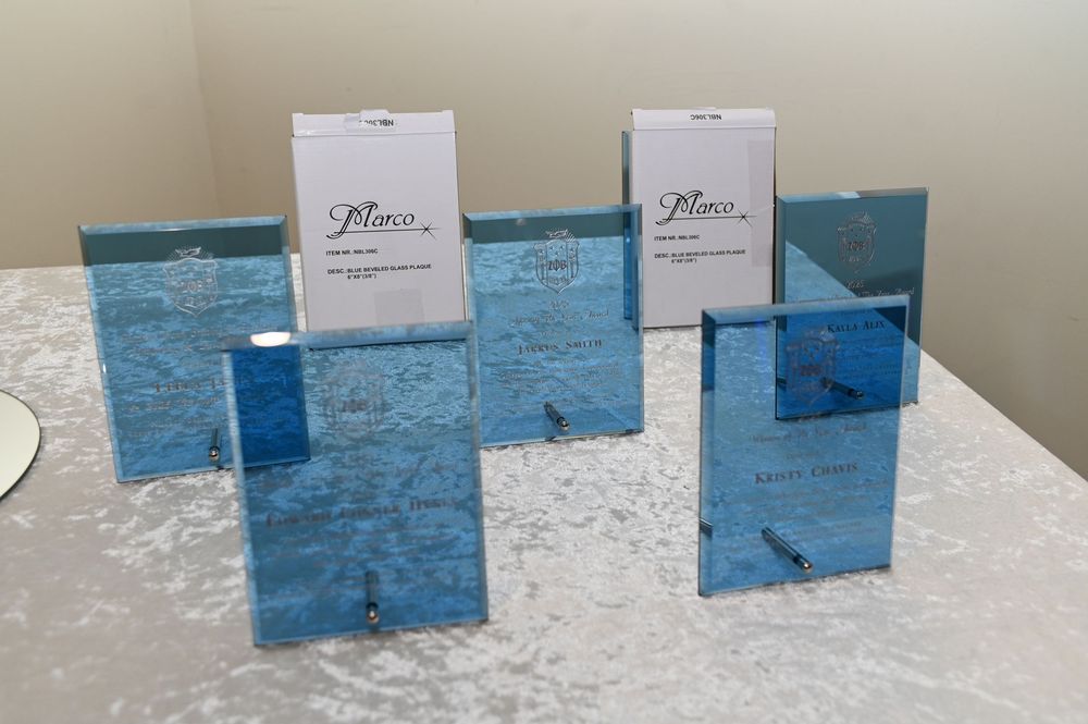 Two modern acrylic photo frames with turquoise blue patterns displayed on a white marble surface.