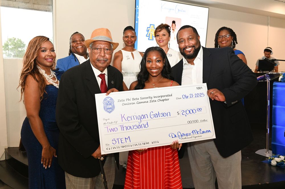 A group of people standing together holding large ceremonial checks.