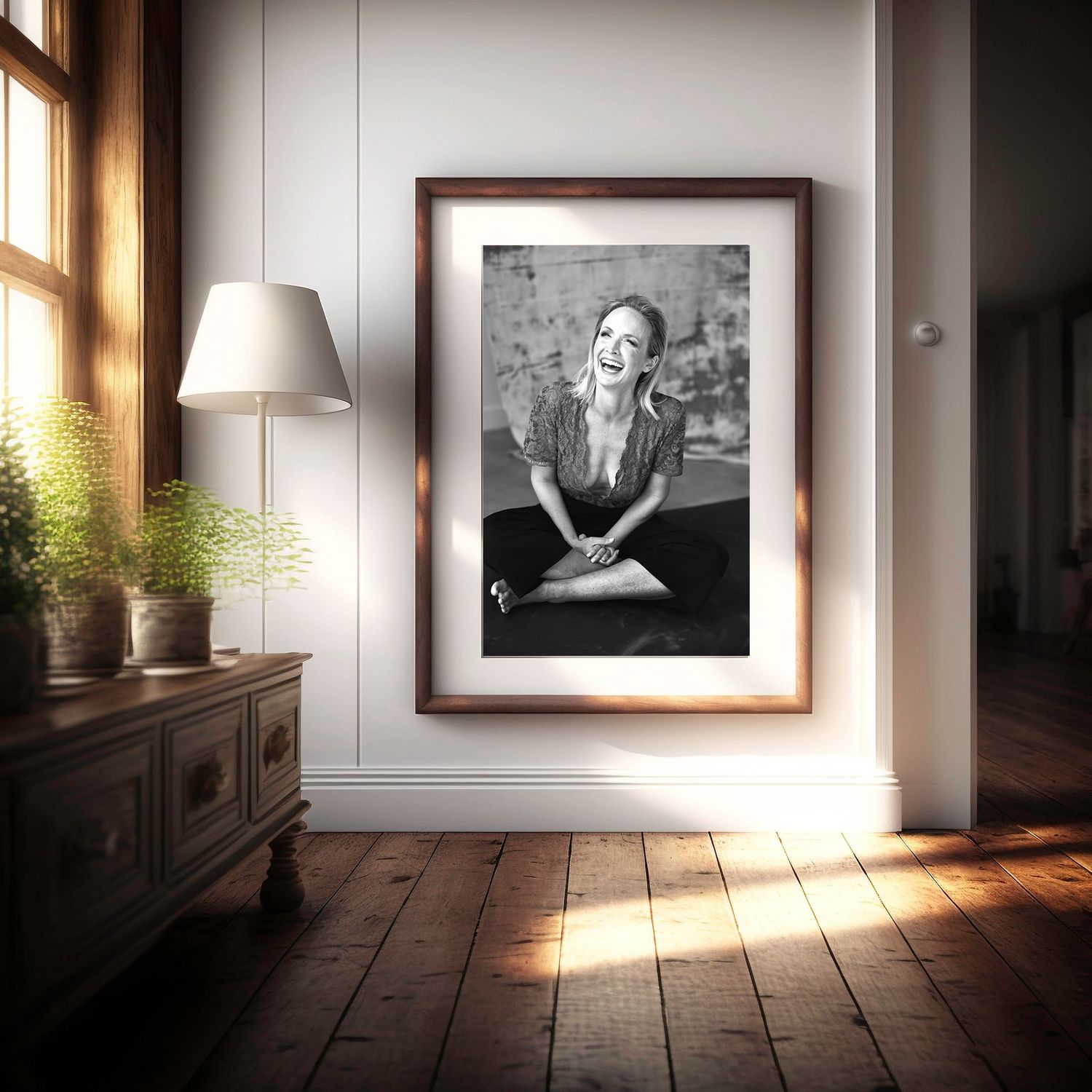 Gallery wall display with black and white photographs in a sunlit room with wooden floors.
