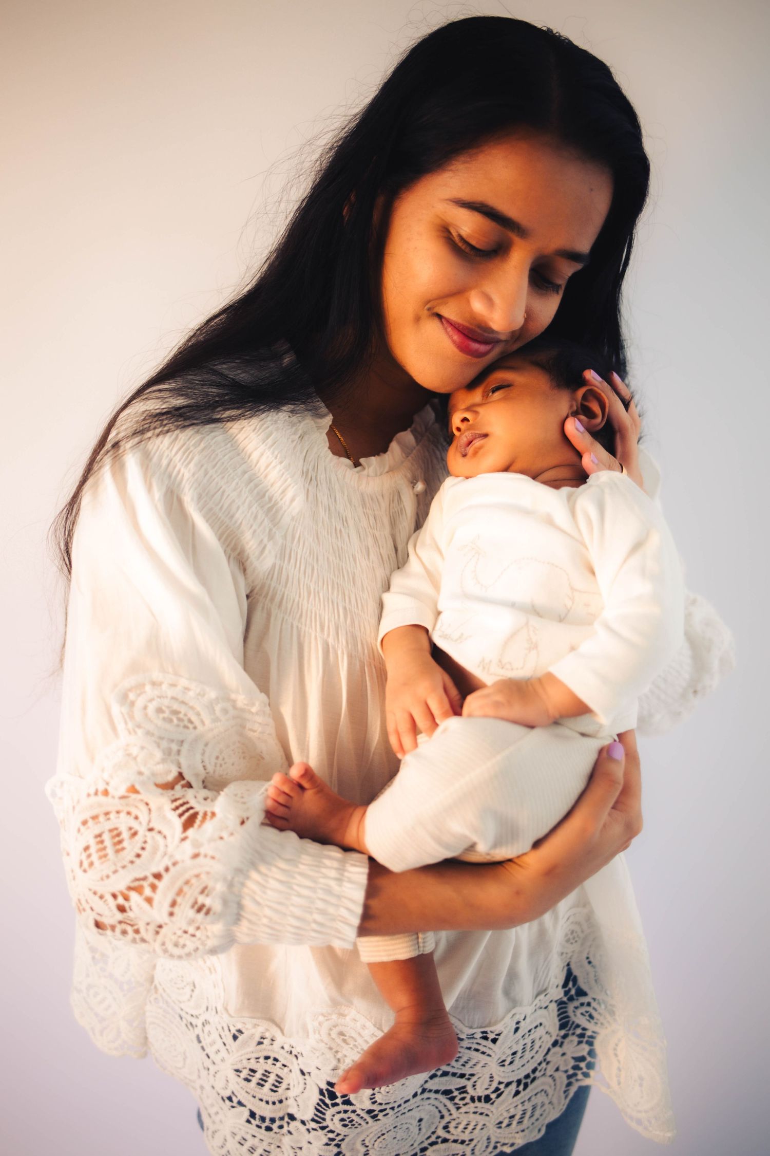 Joyful motherhood portraits with weeping willow backdrop in The Village