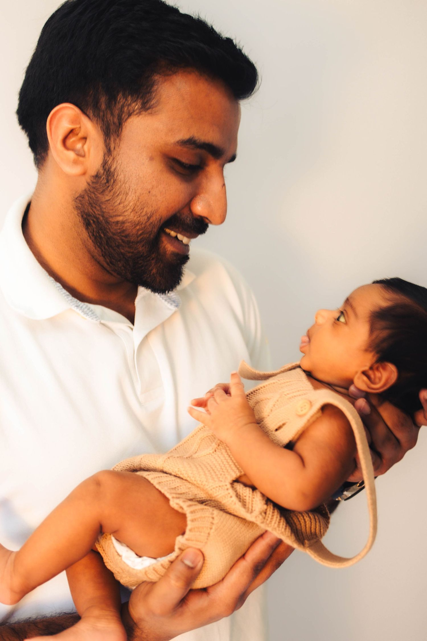 Father holding newborn at home – natural family photography in Moore
