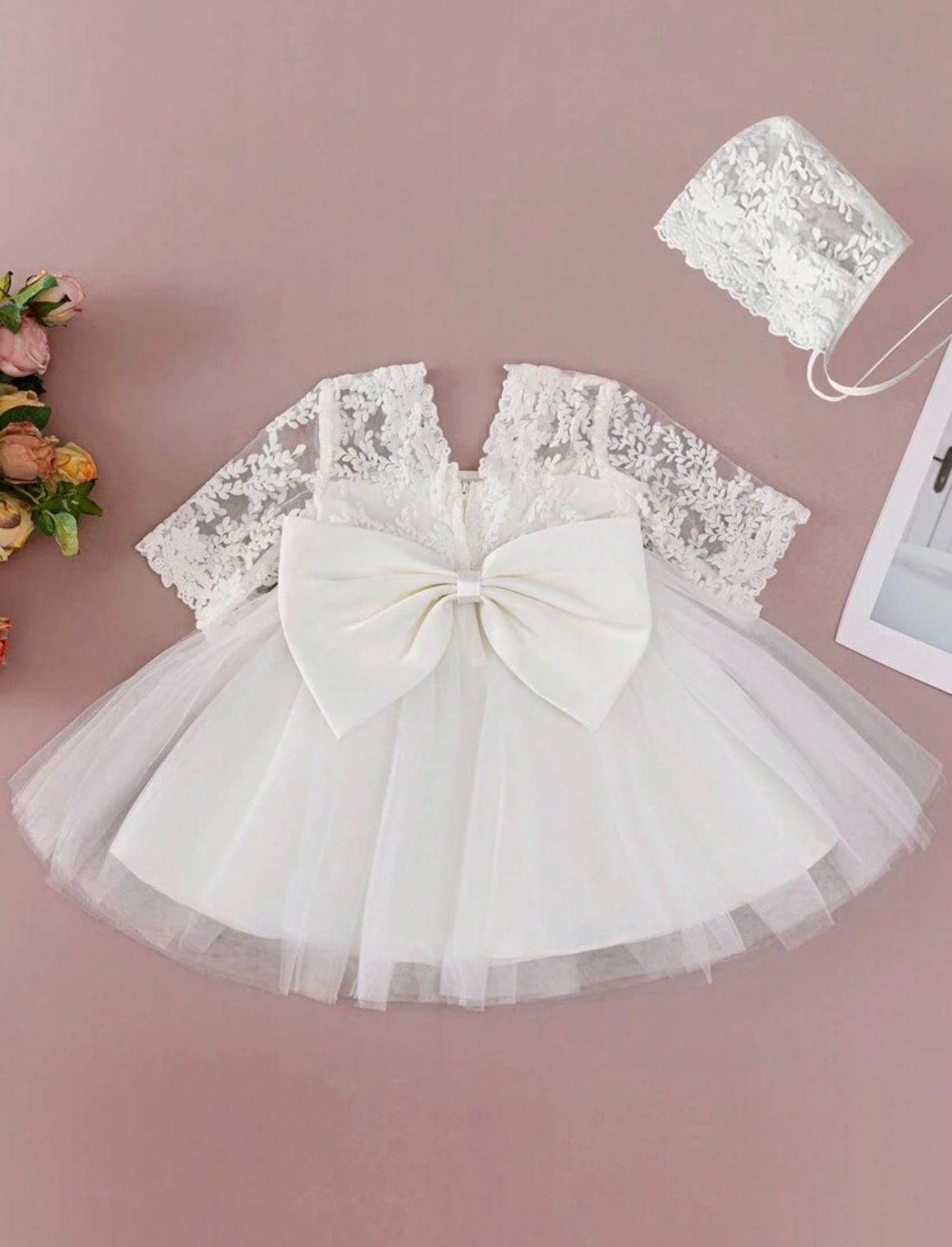 Elegant white lace baby dress with tulle skirt and large bow detail for special occasions.