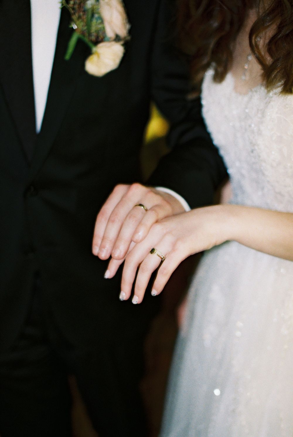 bride and groom show off their wedding rings on 35mm film