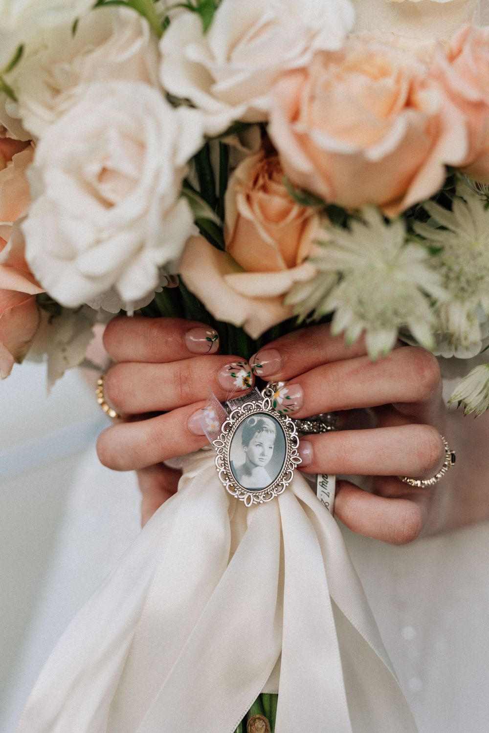 bride shows off charm of her grandmother on her wedding bouquet