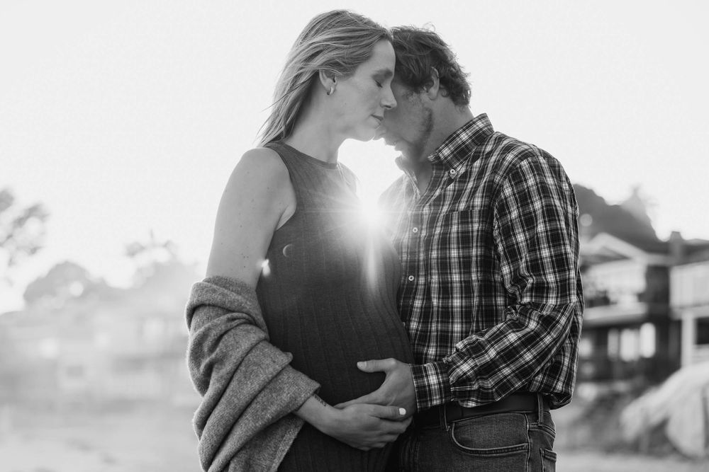 Couple walking along the beach during sunset maternity session in Montecito