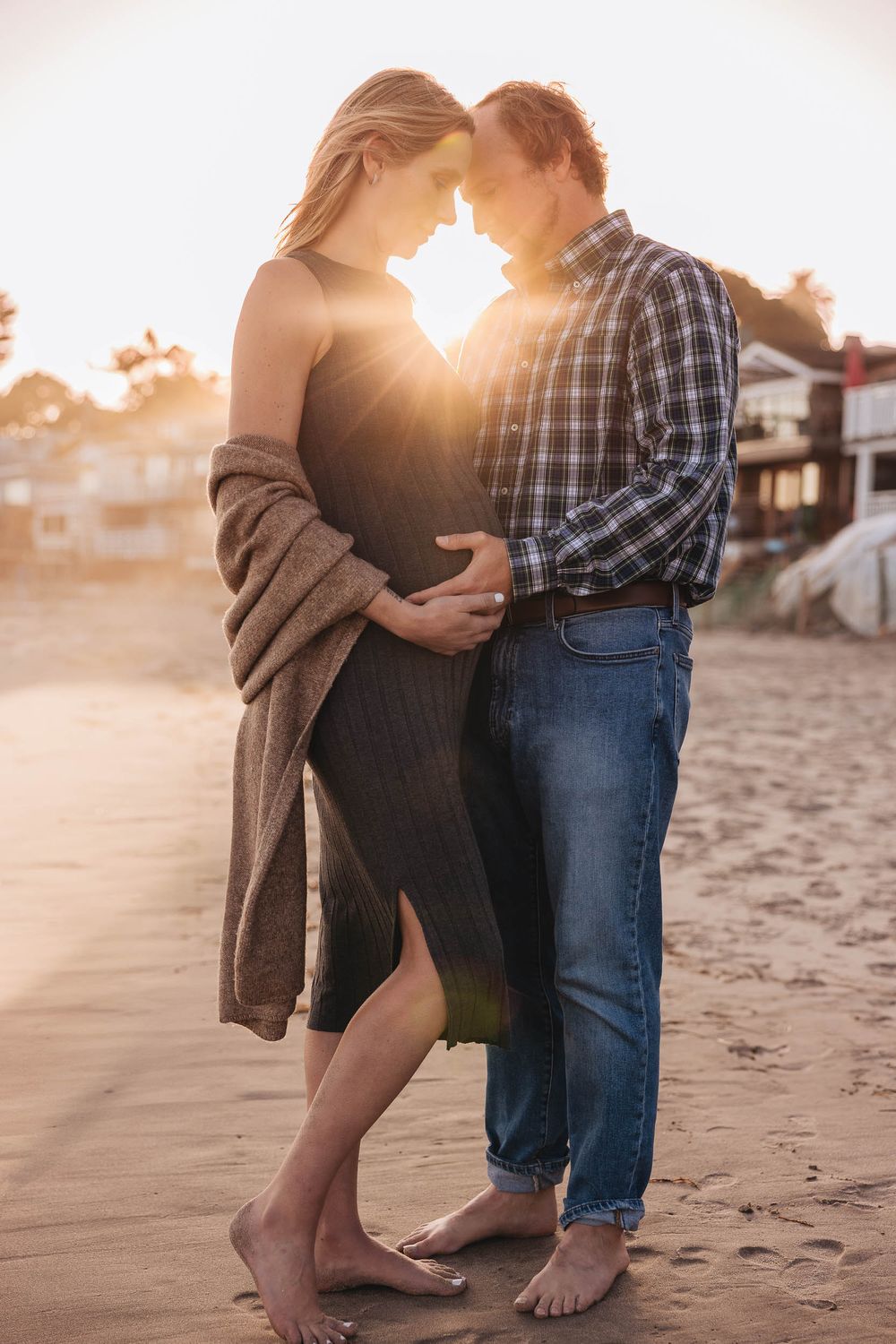 Candid moment between couple during maternity session at the beach in Santa Barbara