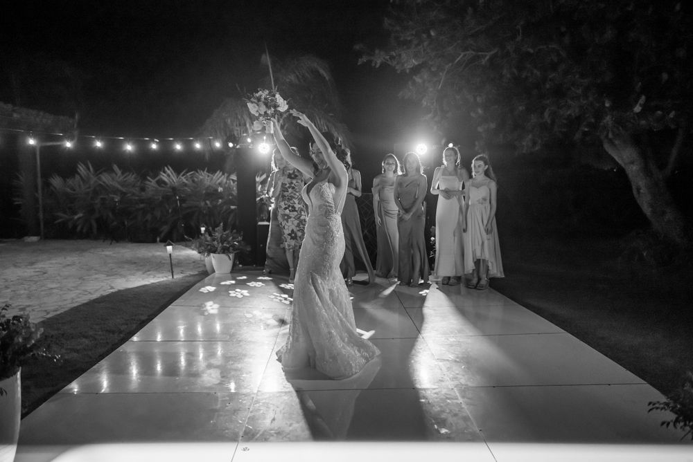 Illuminated dance floor scene at nighttime wedding celebration with string lights overhead.