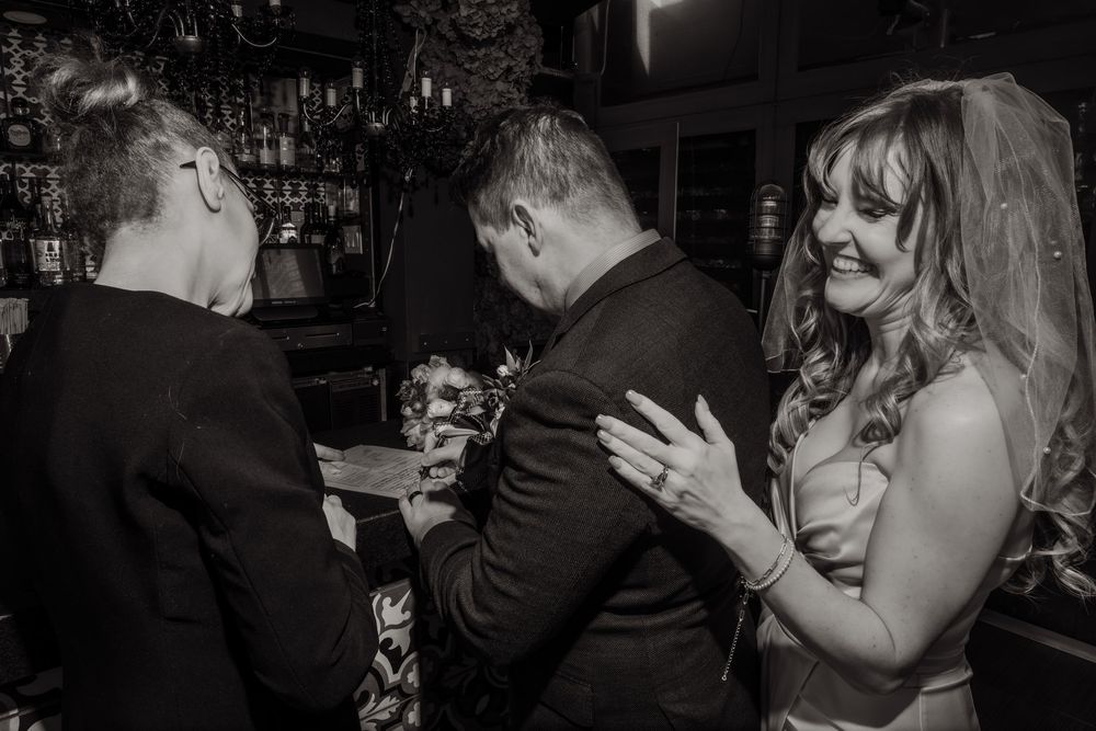 A candid black and white moment captured during a celebration at a bar.