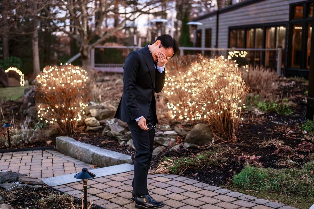 A formal event setup on a stone patio with decorative lighting and winter landscaping.