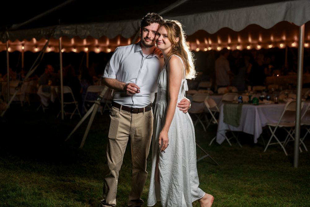 A romantic evening celebration with string lights and a rustic outdoor setting at dusk.