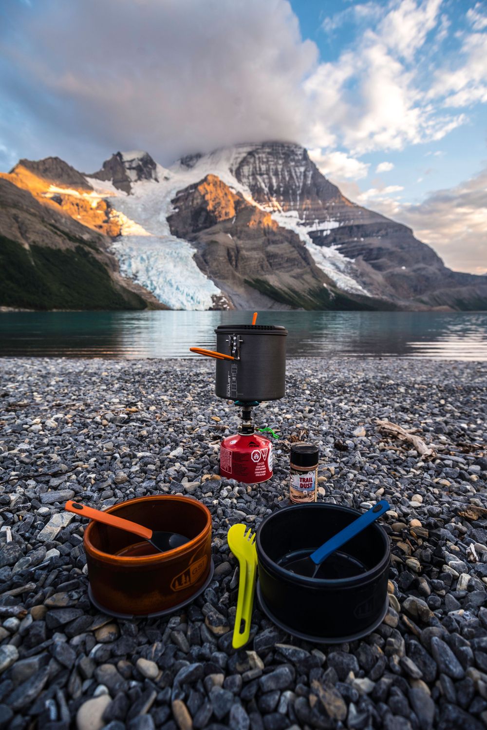 Camping stove and cookware setup with glacial mountain backdrop at Berg Lake.