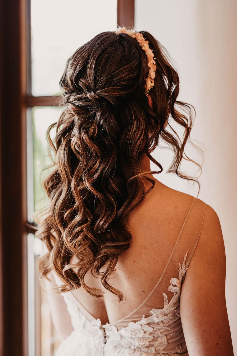 Close-up of intricate bridal hairstyle with soft curls and delicate hair accessories.