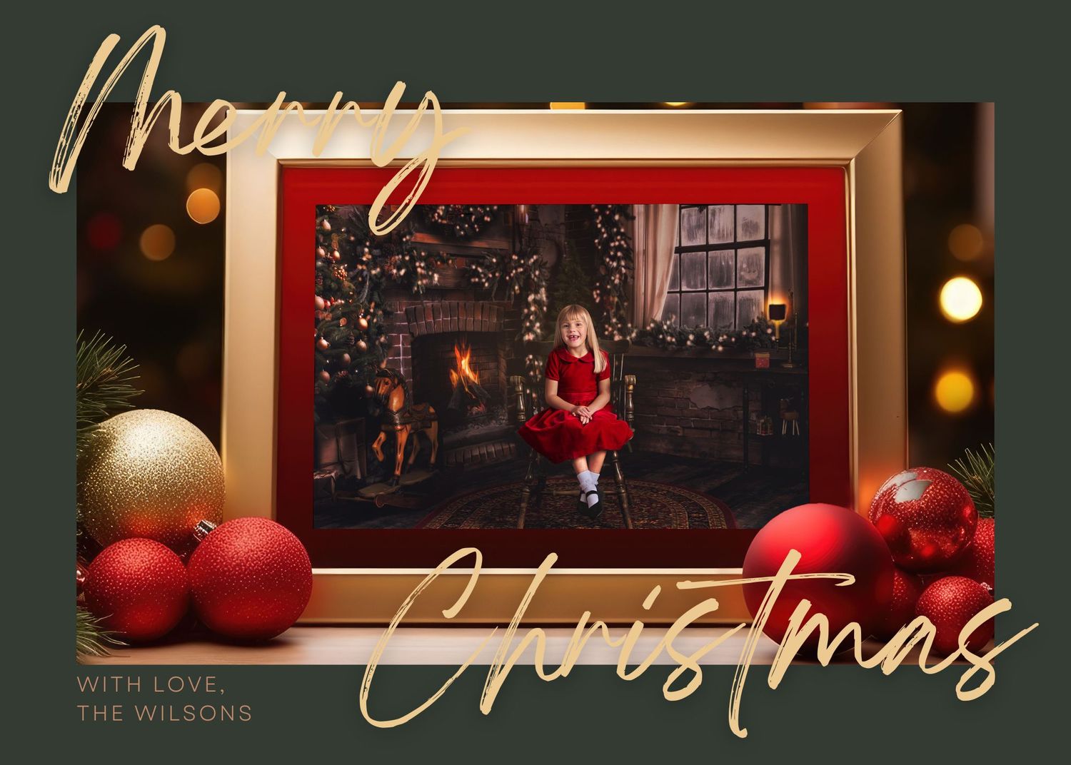 Young girl in red velvet dress sitting on wood club chair in front of a rustic fireplace Christmas scene framed and set on a Christmas card.