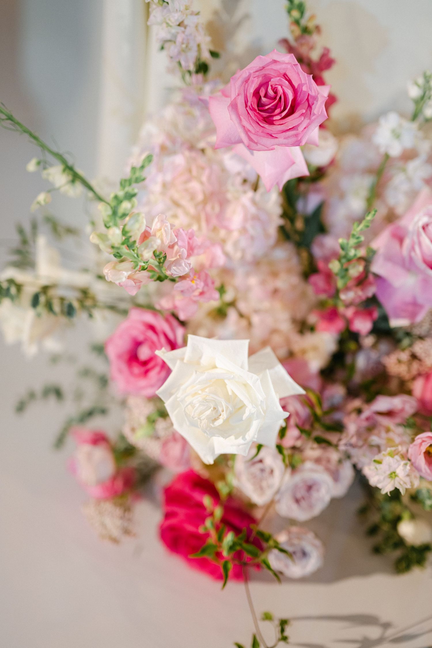 Romantic pink and white floral arrangement with roses and delicate blooms in soft focus creating a dreamy atmosphere.