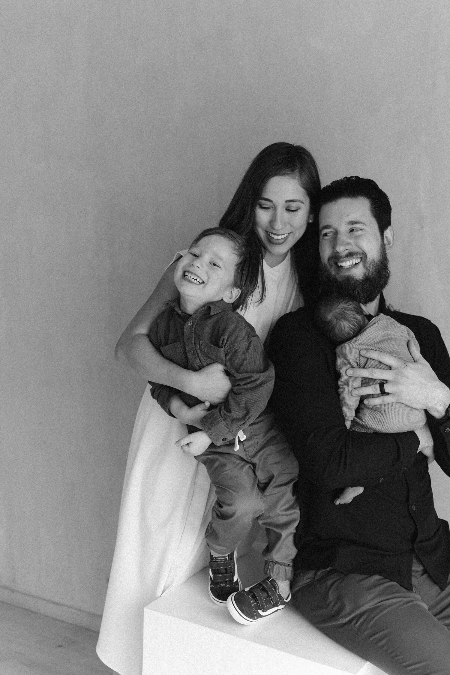 Family newborn photos with parents and big brother holding their baby during an Orange County studio session