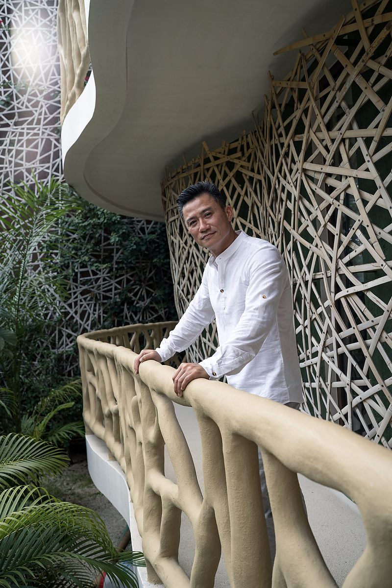 Groom portrait on an organic architectural balcony at KAN Tulum, surrounded by textured jungle design elements.