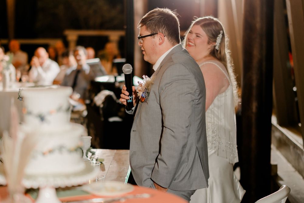 A wedding couple dances together during their first dance at an elegant indoor reception venue.