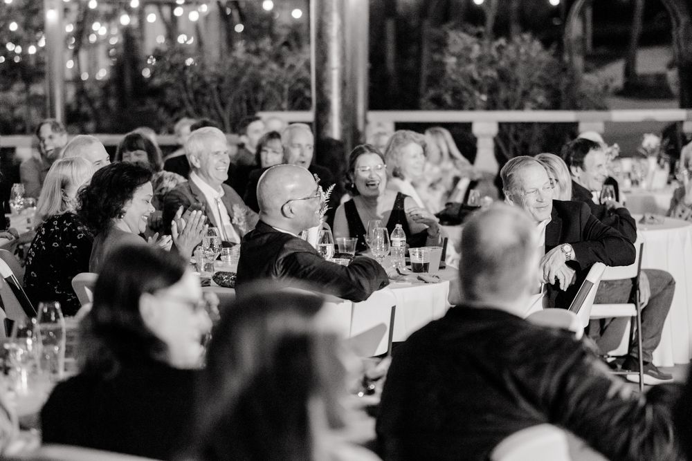 Black and white photo showing wedding guests mingling at an elegant reception celebration.