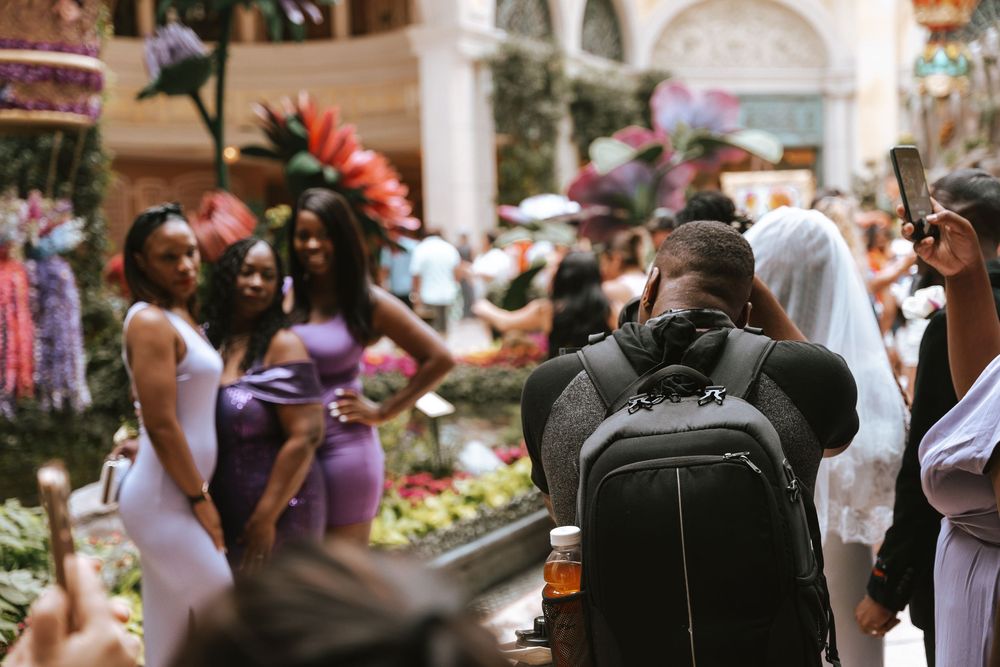 Wedding guests dance and celebrate together during a lively reception on a sunny outdoor patio.