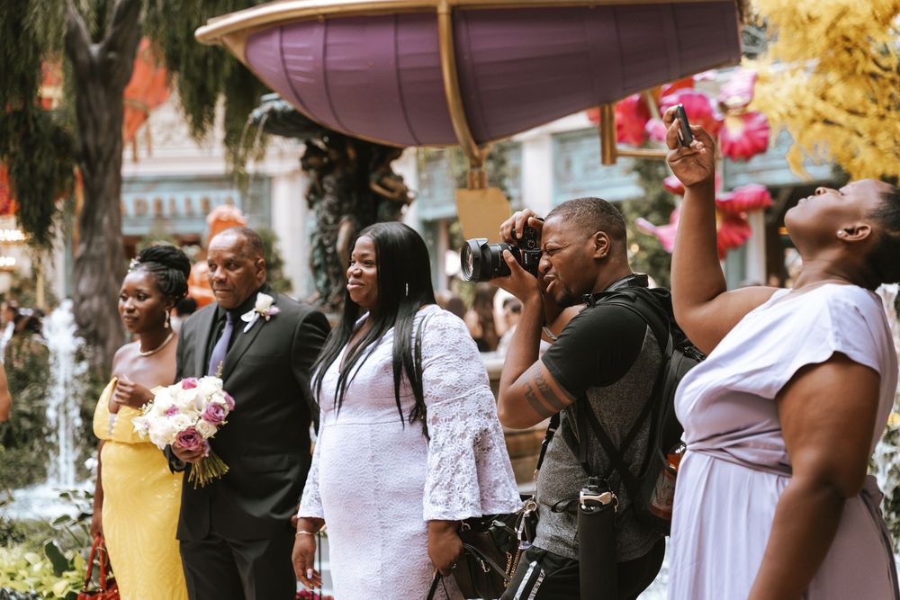 A joyful wedding celebration with guests dancing and celebrating outdoors on a sunny day.