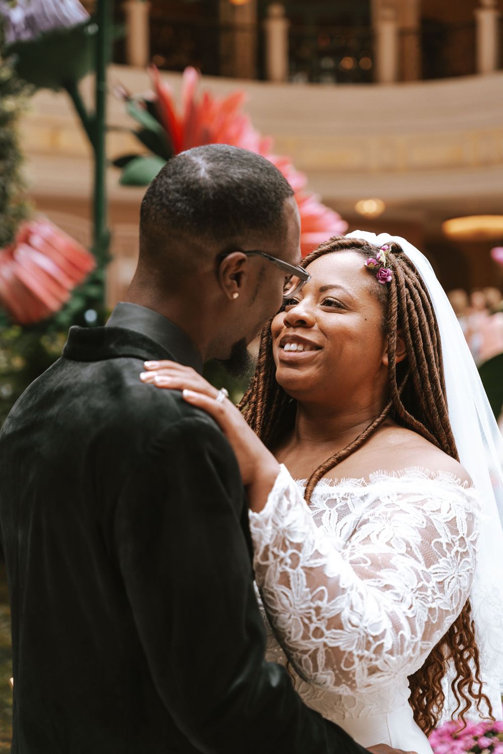 A joyful couple shares an intimate moment on their wedding day, with the bride wearing a white lace dress.