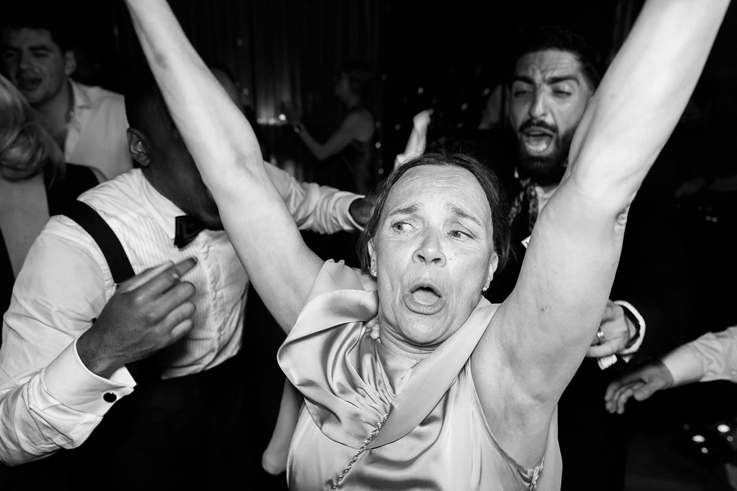 A black and white photo strip shows four sequential frames of people celebrating and raising their arms in excitement.