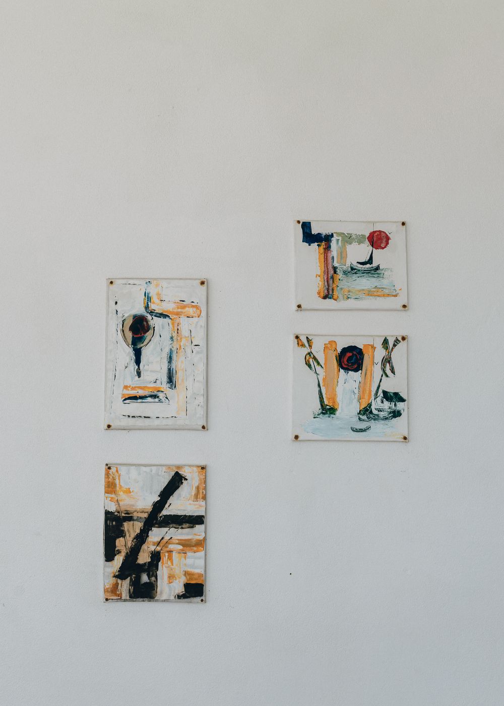 Abstract art series displayed on white wall featuring minimalist compositions in black and orange tones.