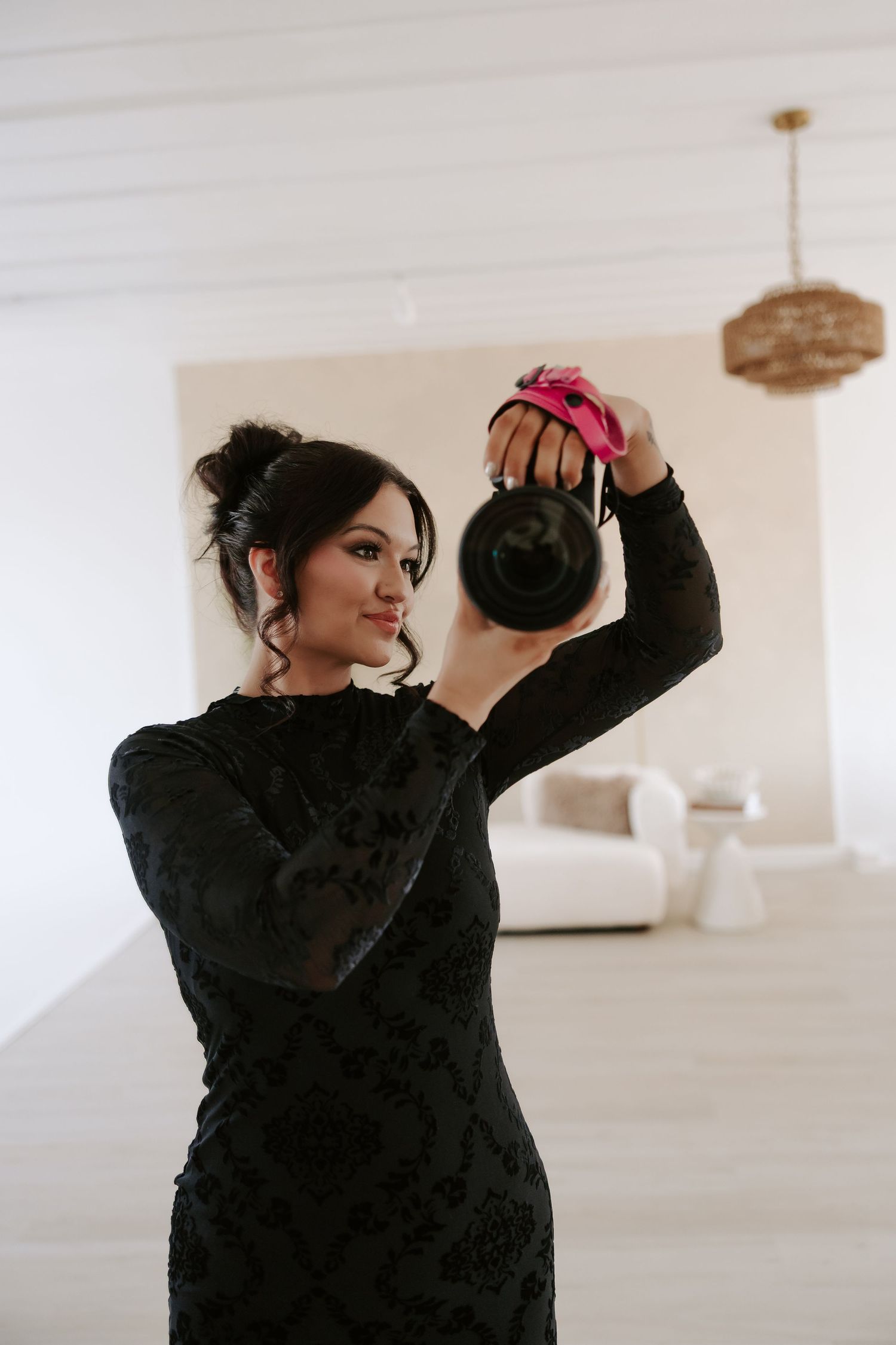 Playful poses with a coffee mug in a bright white room decorated with floral arrangements.