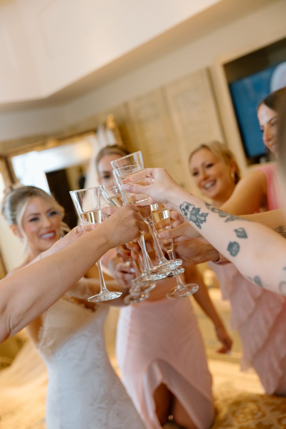 Wedding party toasts with champagne glasses in an elegant indoor setting.