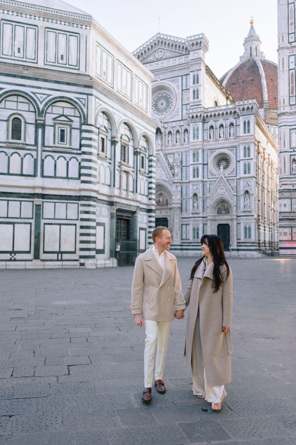 A romantic black and white photo series of a couple in light colored outfits sitting by a waterfront Florence Tuscany couples photographer.