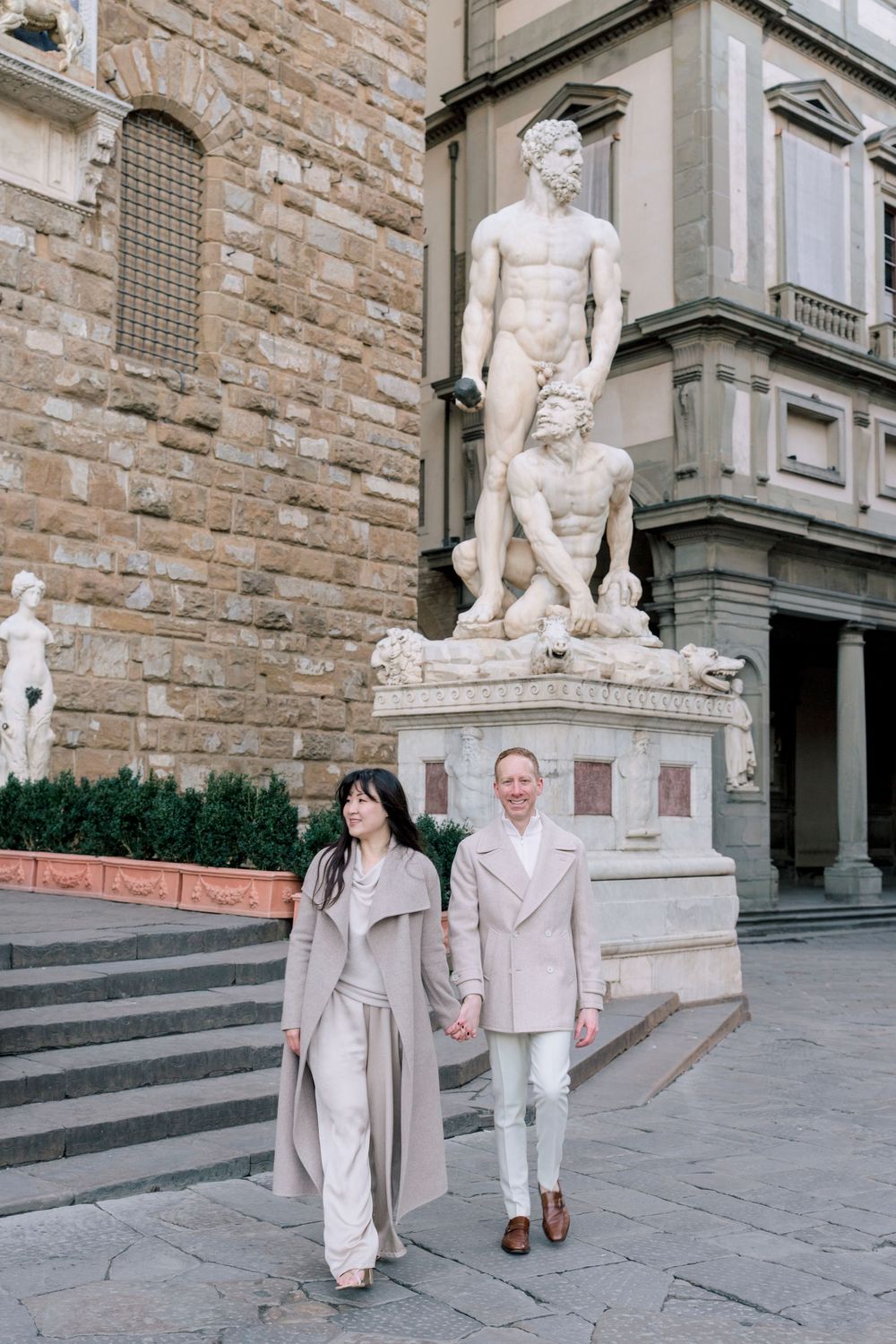 A romantic black and white photo series of a couple in light colored outfits sitting by a waterfront Florence Tuscany couples photographer.