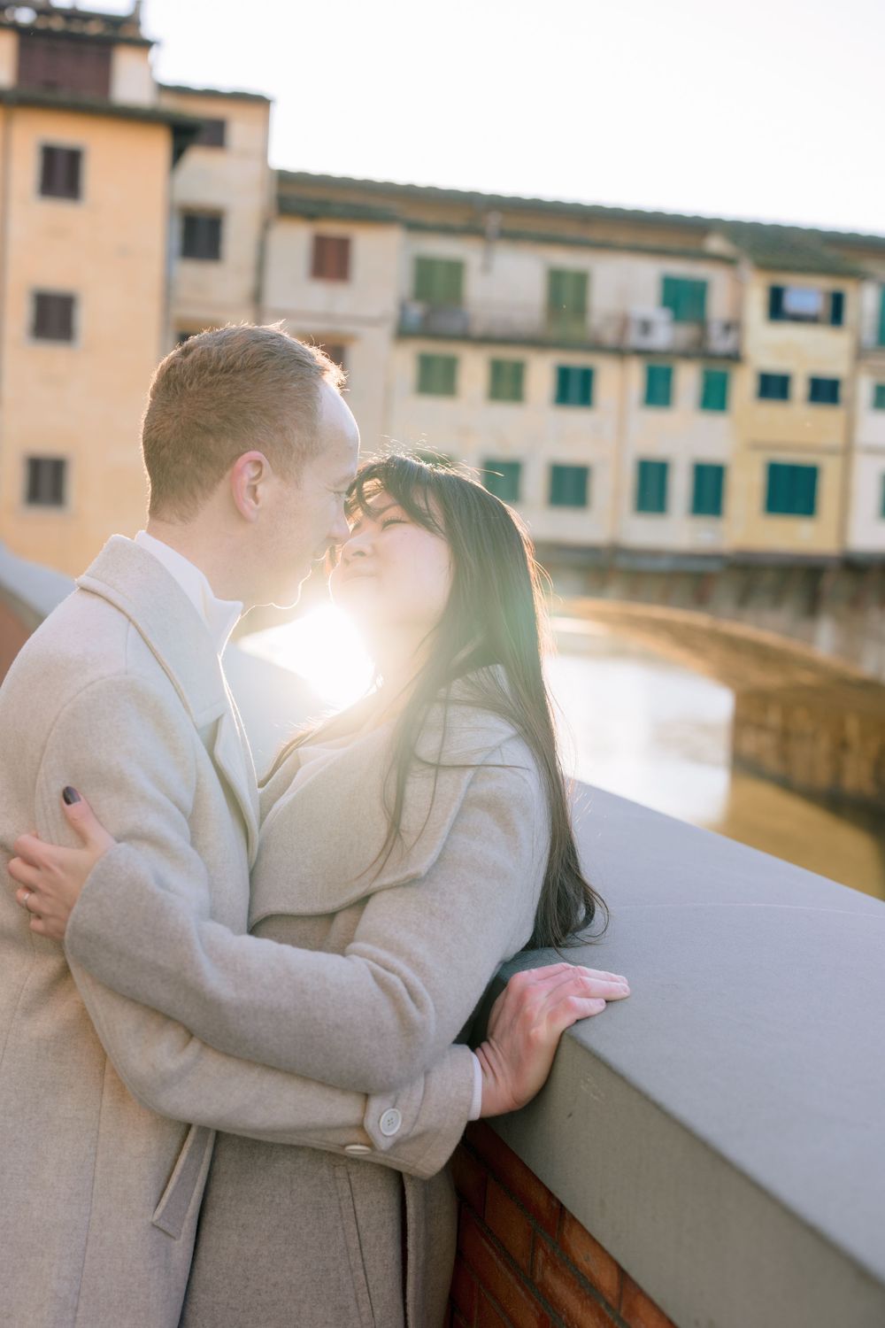 A romantic black and white photo series of a couple in light colored outfits sitting by a waterfront Florence Tuscany couples photographer.