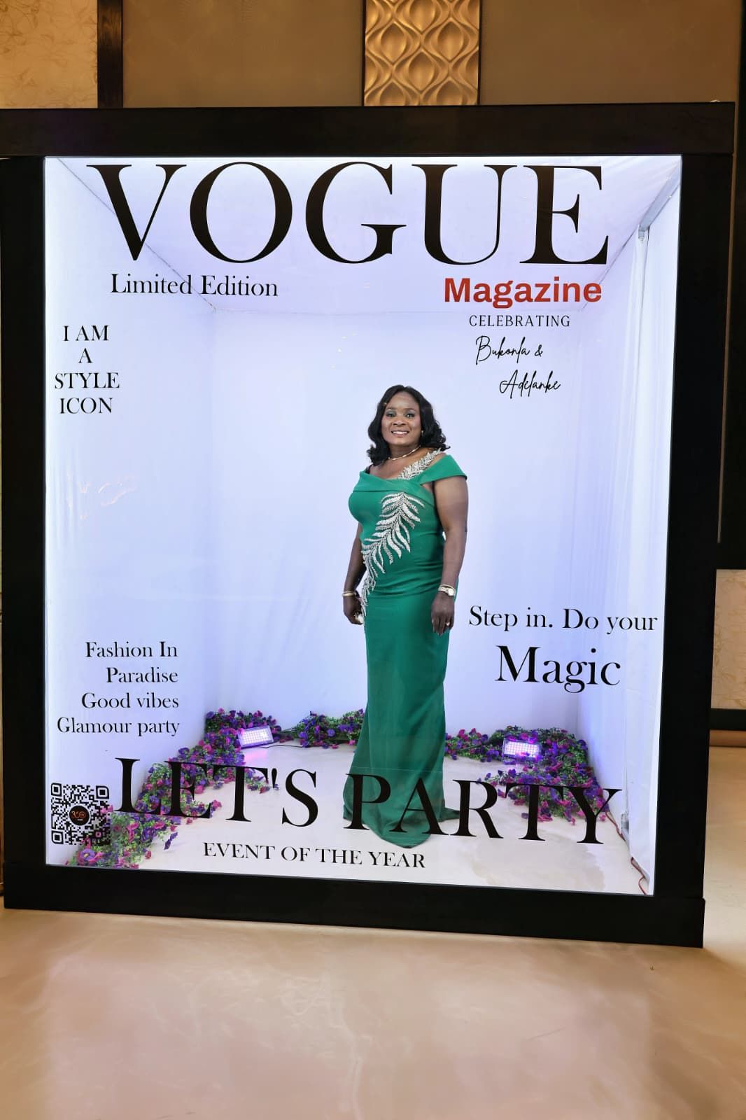 Woman in elegant green gown posing inside a Vogue Magazine Limited Edition party photo booth.
