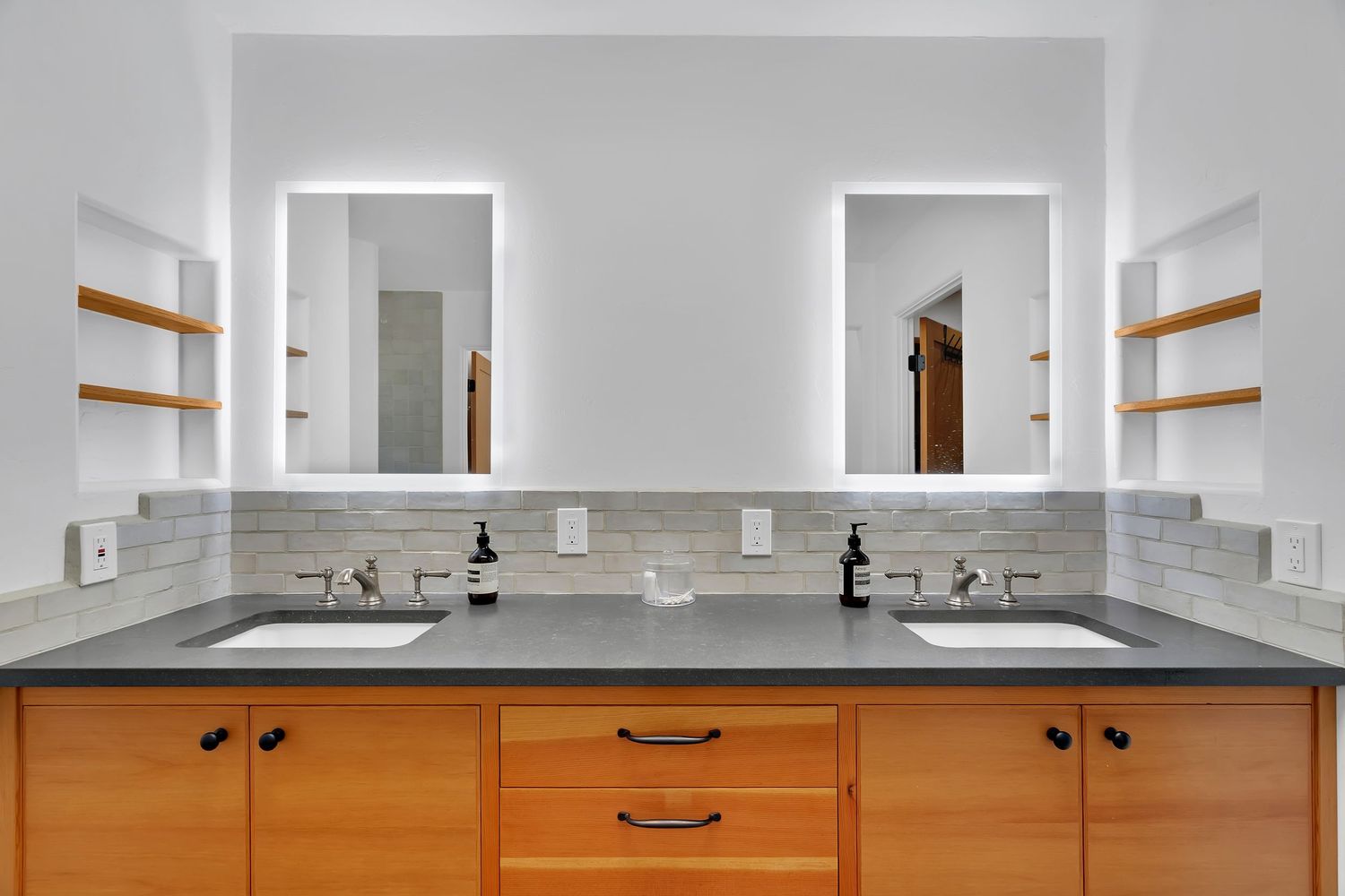 Modern bathroom vanity with wooden cabinets, double sinks, and gray countertops.