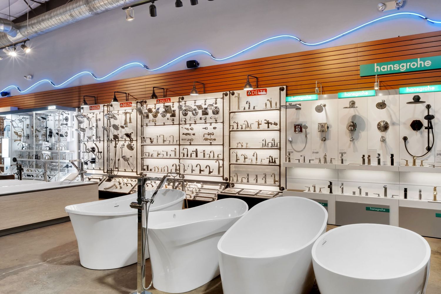 Retail display area with white bathroom fixtures and modern lighting arranged in neat rows.