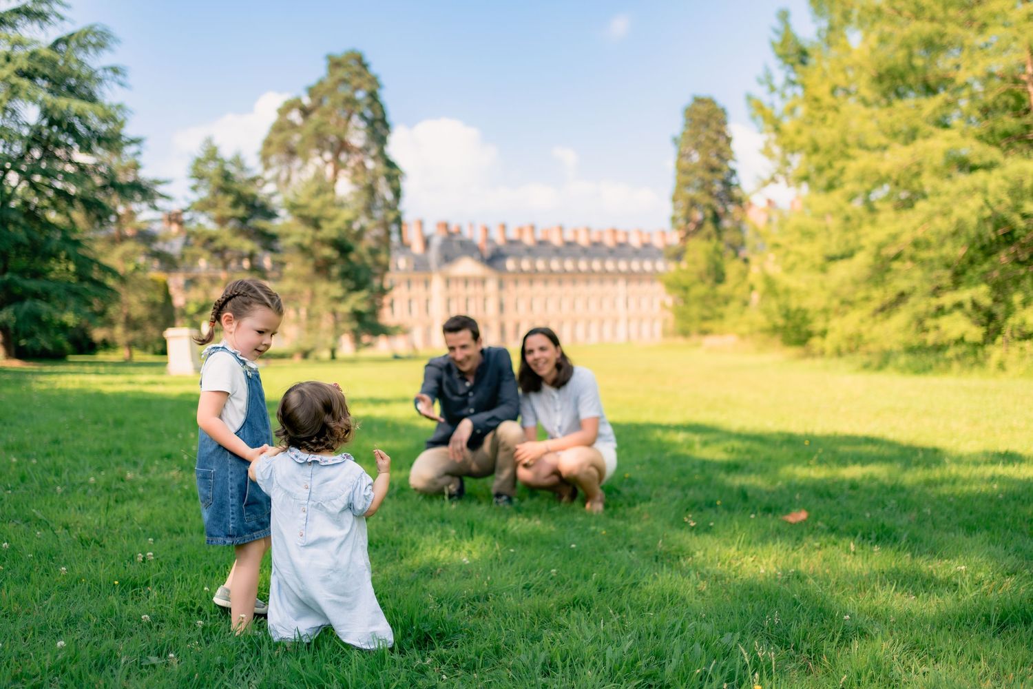 Famille jouent avec leurs enfants dans le parc ensoleillé du château de Fontainebleau