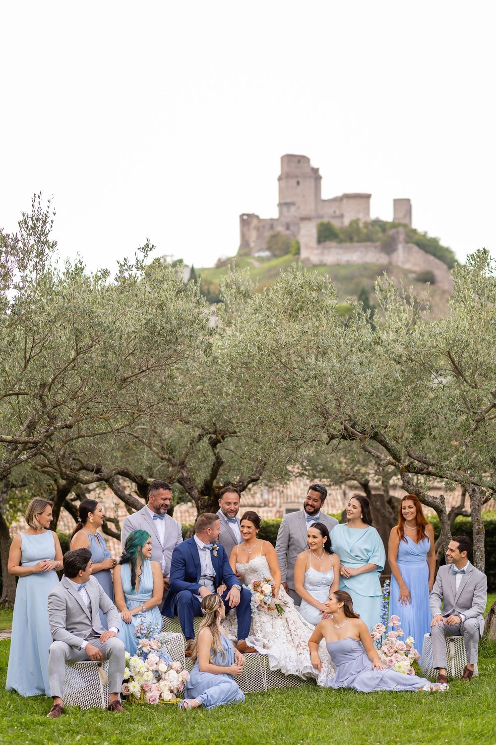 Bridal party in pastel tones celebrating a destination vow renewal in the olive gardens of Assisi, Italy.