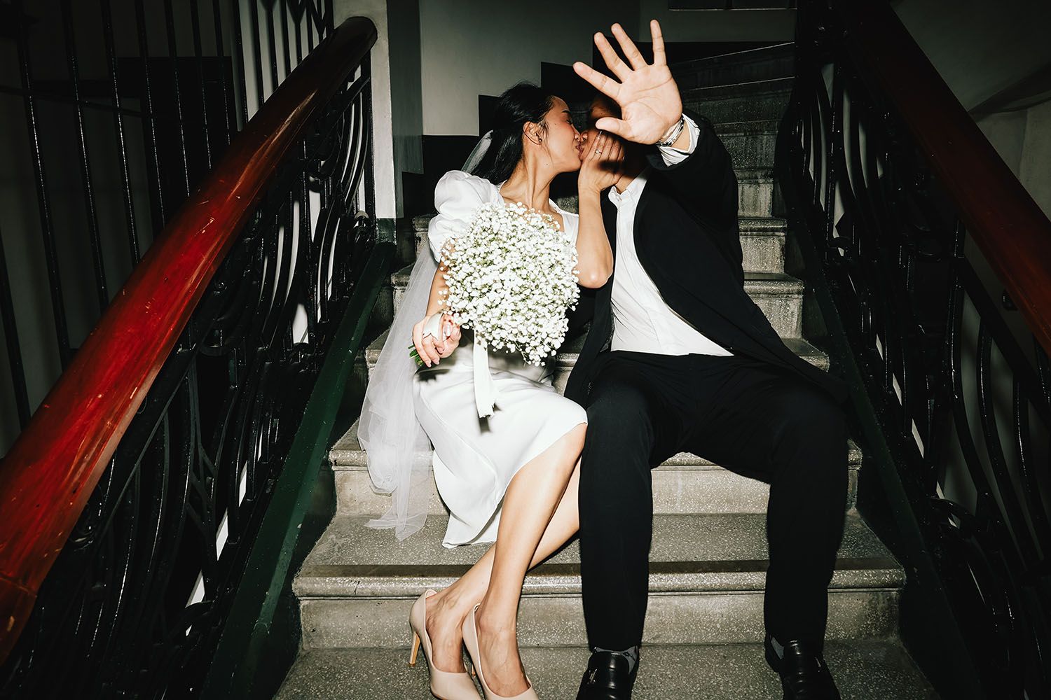 A couple in formal attire descends a dark staircase enjoying a moment not to be disturbed